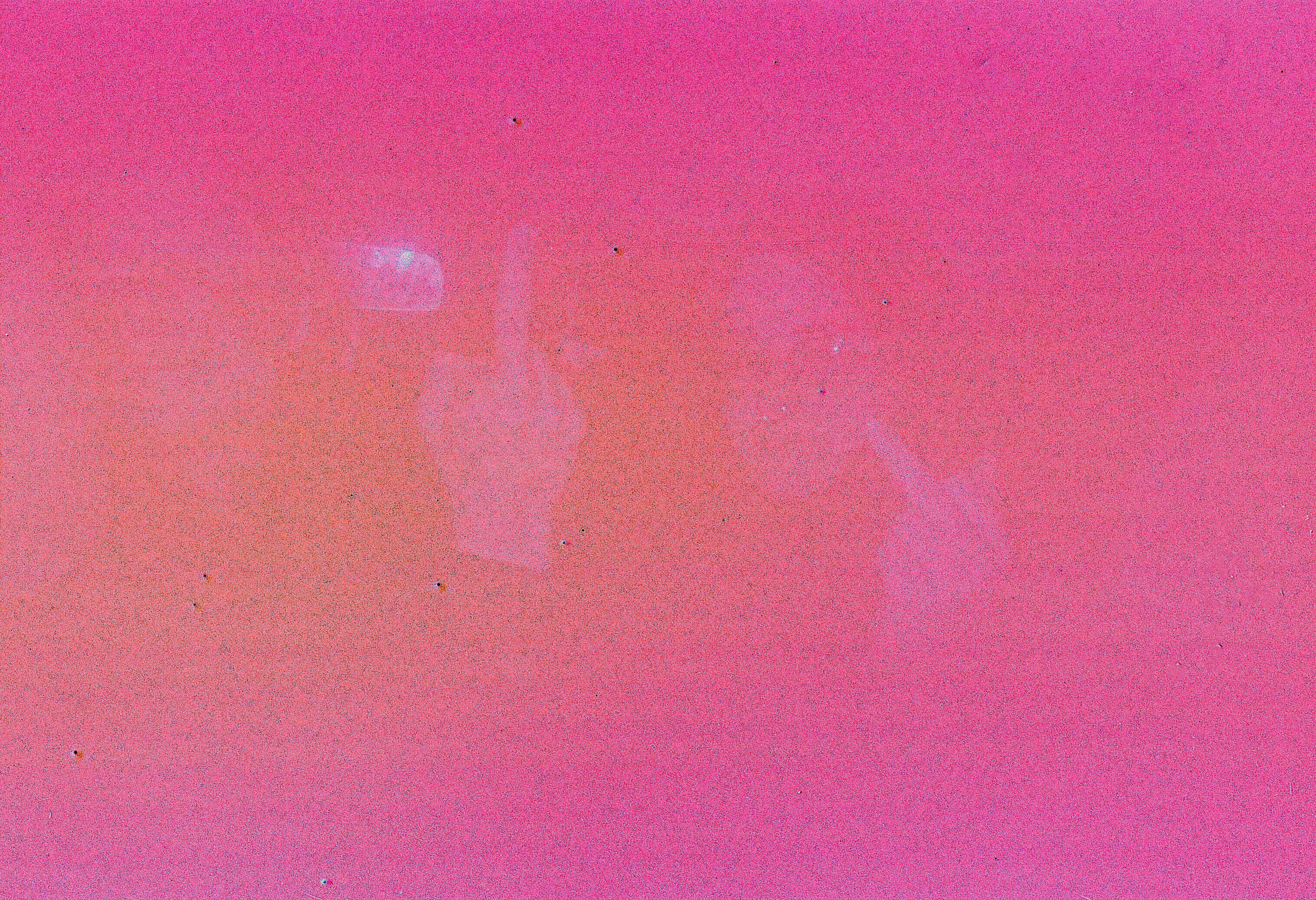 Very pink, foggy photo where two hands flipping the camera off from the front seat of a car are barely visible.